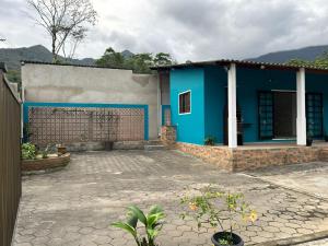 een blauw-wit huis met een binnenplaats bij Cantinho da serra in Ubatuba