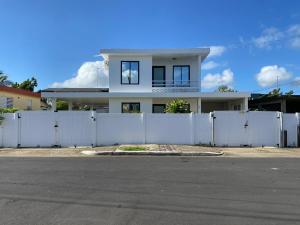 阿瓜迪亚Tropical Getaway的白宫前的白色篱笆