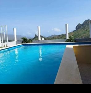 ein großer blauer Pool mit Bergen im Hintergrund in der Unterkunft Splanada poilon in Assomada + 196 Fotos