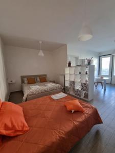 a bedroom with a large bed with an orange blanket at A casa di Pablo in Collodi