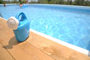 una taza azul sentada en el borde de una piscina en Villa Carolea, en Acireale