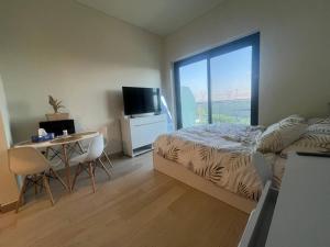 a bedroom with a bed and a desk and a television at The Perfect Couples Nest in Dubai