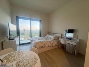 a bedroom with a bed and a desk and a window at The Perfect Couples Nest in Dubai +40 photos
