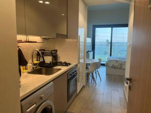 a kitchen with a sink and a washing machine at The Perfect Couples Nest in Dubai