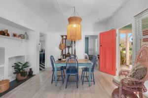 a dining room with a blue table and chairs at Atlantis retro beachside couples retreat in Currarong