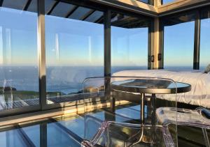 a bedroom with a view of the ocean at Atatū PurePod in Tormore +6 photos