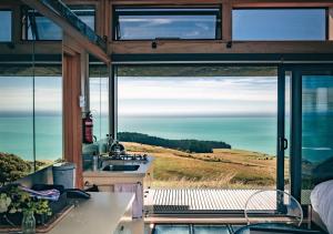 a kitchen with a view of the ocean from a house at Atatū PurePod in Tormore