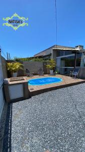 a swimming pool in the backyard of a house at Studio aconchegante para duas pessoas in Bombinhas