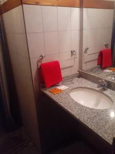 a bathroom with a sink and a red towel at Cabañas UN LUGAR in Villa General Belgrano