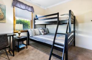 北迈尔斯堡Lazy Palm Retreat Heated Pool Jacuzzi Gulf Canal的一间卧室，配有两张双层床和一张书桌