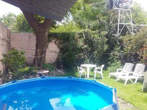una piscina en un patio con mesa y sillas en Hostal Namaste en Salta