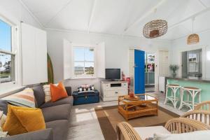 a living room with a couch and a table at Aurora quintessential beachfront couples getaway in Currarong