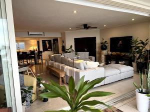 a living room with a large white couch and a table at BEACH GETAWAY! Luxury Beachfront Condo in Punta de Mita! in Punta Mita