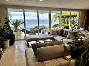 a living room with couches and a view of the ocean at BEACH GETAWAY! Luxury Beachfront Condo in Punta de Mita! in Punta Mita