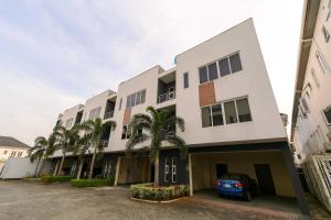 a building with palm trees in front of it at George Residence Osapa, Lekki in Lekki