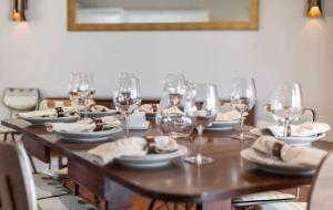 a wooden table with wine glasses and plates on it at Tranquil Palms Heated Pool Spa Outdoor TV & More in Cape Coral