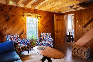 a living room with a couch and chairs and a table at Cozy Cottage with Jacuzzi and Fire Pit and Reading Nook! in Livingston Manor