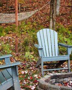 a blue rocking chair sitting next to a hammock at Cozy Cottage with Jacuzzi and Fire Pit and Reading Nook! in Livingston Manor