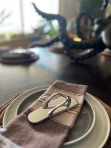 a pair of tongs sitting on a plate on a table at BEACH GETAWAY! Luxury Beachfront Condo in Punta de Mita! in Punta Mita +58 photos