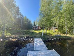 a wooden bridge over a river in front of a cabin at 5 person holiday home in KARLSKOGA in Karlskoga