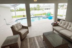 珊瑚角Pelican House 4 bedrooms Free Heated Pool的带沙发和椅子的客厅以及游泳池。