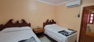 a bedroom with two beds and a window at Hotel Calakmul in Xpujil