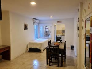 a room with a bed and a table and chairs at Departamentos en Costanera, sobre Alem in Gualeguaychú