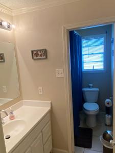 a bathroom with a toilet and a sink and a mirror at 3 bedroom Cozy vacation rental near airport in Kenner +11 photos