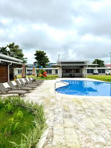 a swimming pool with lounge chairs and a building at Viva Jaco 9-05 in Jacó