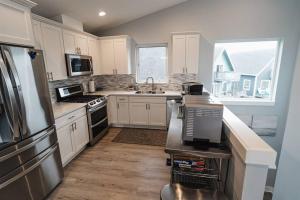 a kitchen with white cabinets and a sink and a refrigerator at Oceans3 - Spectacular View 'N' Jetty Access in Ocean Shores
