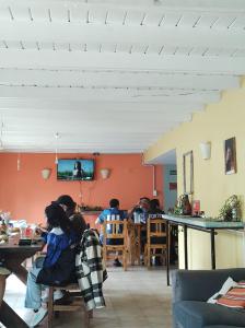 a group of people sitting at tables in a room at Hostel Yatel in El Calafate