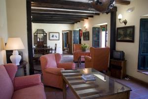 a living room with pink chairs and a table at Molino El Vinculo in Zahara de la Sierra