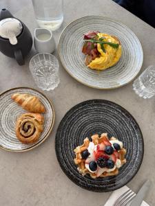 Una mesa con tres platos de comida encima. en Lancemore Milawa, en Milawa