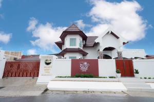 a white house with a red and white fence at The Star Pool Villa Hatyai in Hat Yai