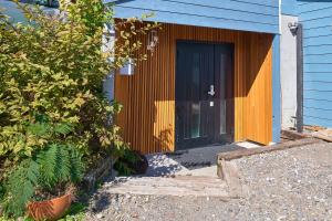 a blue house with a black door and a porch at Sunnsnow ski in apartment in Otari