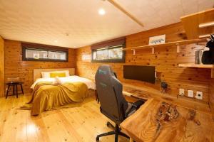 a bedroom with a bed and a desk and a television at Sunnsnow ski in apartment in Otari