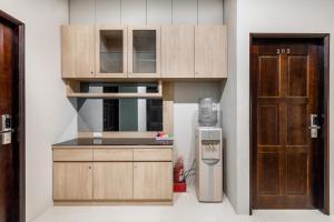 a kitchen with wooden cabinets and a refrigerator next to a door at Summer Crazy in Huxi