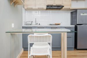 a kitchen with a table and a white chair at Comfy and Cool Interior 1BR at Casa De Parco Apartment BSD By Travelio in Tangerang