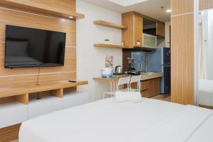 un salon avec une télévision sur un mur dans l'établissement Relax and Simply Studio Apartment at Parkland Avenue By Travelio, à Tangerang