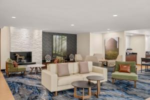 Un vestíbulo con un sofá y sillas y una chimenea. en Fairfield Inn & Suites Naperville/Aurora, en Naperville