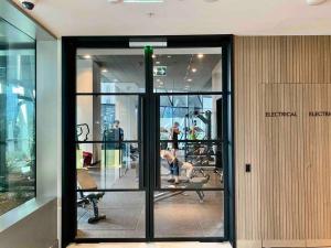 a gym with glass doors in a building at Chic 2BR Luxury Apt in Prime West Side Complex Center of It All in Melbourne