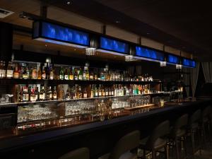 a bar with a lot of bottles of alcohol at APA Hotel & Resort Osaka Namba Ekimae Tower in Osaka