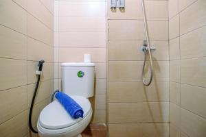 a bathroom with a toilet and a shower at Homey Studio at 10th Floor Margonda Residence 5 Apartment By Travelio in Depok +6 photos