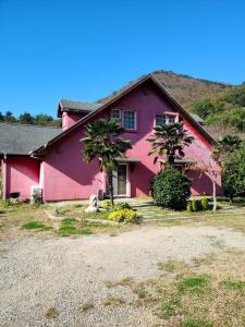 a pink house with two palm trees in front of it at American House in Namhae