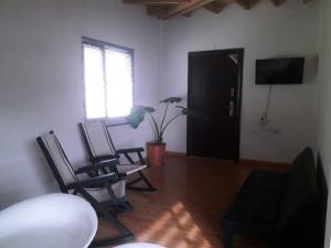 a living room with two chairs and a television at Dpto los rosales in Los Antiguos