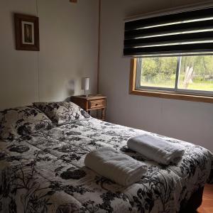a bedroom with a bed with two pillows on it at Raíces del Ñuble in San Fabián de Alico +10 photos