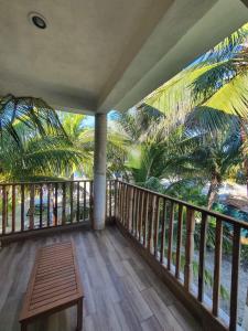 a balcony of a resort with a bench and palm trees at Casa Azul Cielo in Dzilam de Bravo