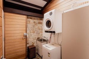 ein Badezimmer mit Waschmaschine und Mikrowelle in der Unterkunft Waterfront Boltons Beach Cottages in Little Swanport
