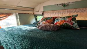 Una cama en una cabaña con almohadas. en Nanku Nimbu Casa-Bus equipada cerca de playas, en Sámara
