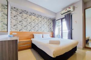 a hotel room with a bed and a window at Fancy and Nice Studio at Atria Residence Gading Serpong Apartment By Travelio in Tangerang +7 photos